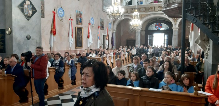 Otwórz zdjęcie Zdjęcie przedstawiające ludzi w ławach, w kościele
